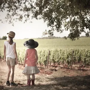 two children walking vineyard lane